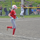 A player catches the ball in the background, making the New Bedford player out. 