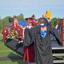 A student and a member of staff celebrate after the student received his diploma. 