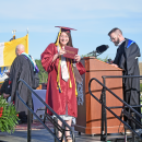 A student poses with her diploma. 
