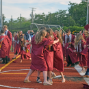 A group of students celebrate after graduating. 