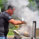 A man grills up some kebabs. 