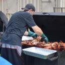 One of the cooks at Pig Pickin' tears apart the pig. 