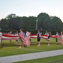 Dartmouth and Bishop Stang students hold a flag. 