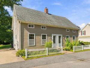Front of the duplex at 17 Beeden Road in Westport, MA, with a white picket fence and double front doors
