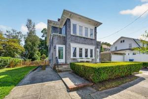 Front of 370 Maple Street, a cedar-shingled two-family home with trimmed hedges across from Buttonwood Park, New Bedford