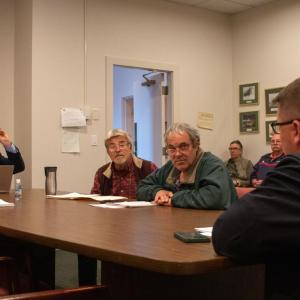Bob Bouley and Bill Coutu of the Fire District 2 Prudential Committee inform Greg Edgcomb (right) that his contract as acting fire chief will be terminated. Photo by: Morgan Beard