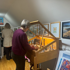 Linda Mae Kristofik stocking some of her jewelry in a case. 
