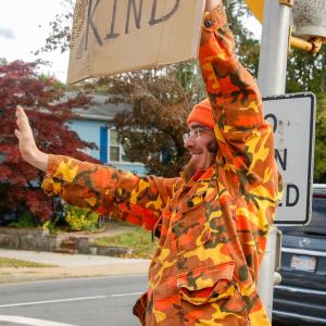 Bean waves to a passing car.