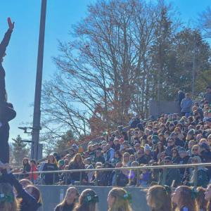 A cheerleader stunts for the crowd. 