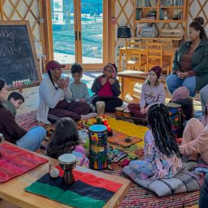 Kids gather around as Samia Walker as she teaches about Kwanzaa.
