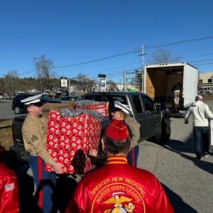 The marines load the toys onto a truck for transport.
