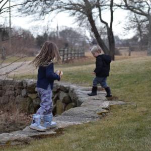 Two children run along the stone fence at Round the Bend Farm. Photos by Kat Sheridan