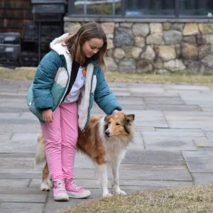 IvyRose Nelson, 8, pets the farm dog.