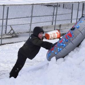Andrew Robitaille, 6, tries to push his tube up a pile of snow.
