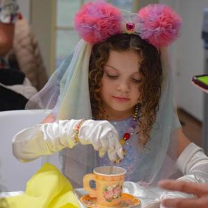 Camila Sovik, age 6, stirs some sugar into her tea. Photos by Kat Sheridan
