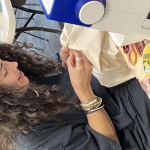 Photo of Claudia De Sousa Baptista mending clothing. Source: Marissa Perez Dormitzer