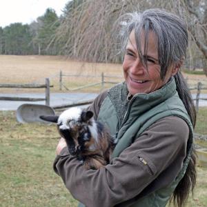 Shannon Lawrence warms up one of the goats.