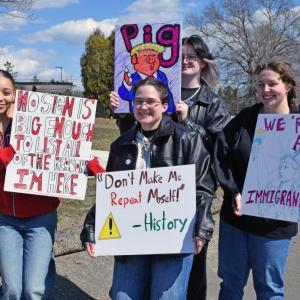 A group of four women show their signs. 