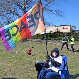 Jeanne Robinson, the organizer of the Dartmouth protest, waves a peace flag.