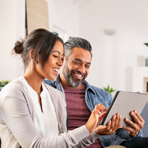 Picture of a couple looking at a tablet. 