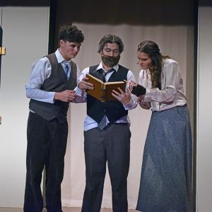 Dimirtry (Jack Nylin,) Vlad (Nolan Woodard,) and Anya (Emerson Palumbo) look at a book on the royal family. 