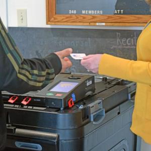 A voter grabs an "I voted" sticker. 