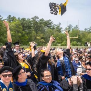 The students toss their caps in the air in celebration. Source: David James 