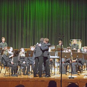 Noah Veloso hugs percussion director Alex Ollivierre. 
