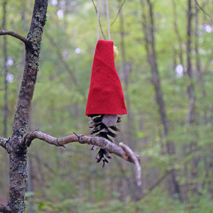 A gnome hangs behind a branch. 