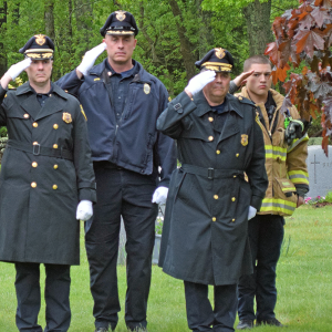 Members of the police and fire department salute during "Taps."