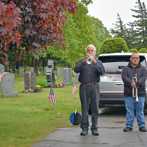 The crowd listens to a member of the Dartmouth Community Band perform "Taps."