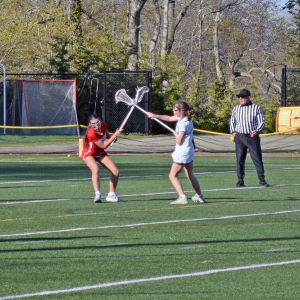 Kaylie Tyler crosses sticks with an opposing player. 