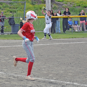 A player catches the ball in the background, making the New Bedford player out. 