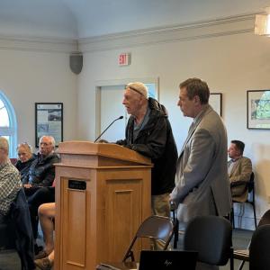 Michael Woyciechouski speaks with Town Counsel Anthony Savastano standing nearby. 