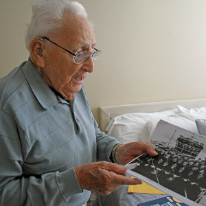 Enos shows a picture of the crew he was with. 