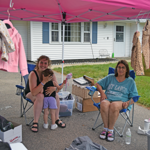 Destiny and Madeline pose at their yard sale.