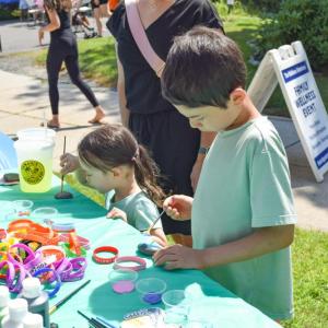 Joel, 8, and Lilia, 3, paint rocks at a craft station. 
