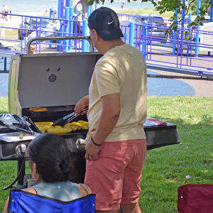 A man grills some squash. 