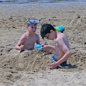 Two boys play in the sand. 