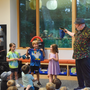 Grace, 7, Arlo and Riley participate in a magic act. Arlo accidentally pulled a chicken out of the bag, not a dino. 