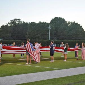 Dartmouth and Bishop Stang students hold a flag. 