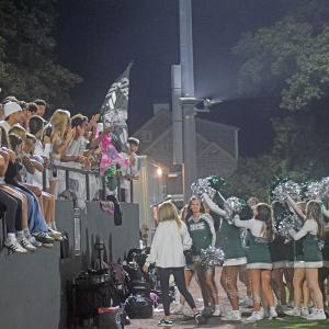 The cheerleaders and students celebrate together. 