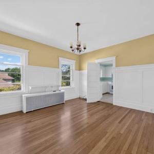 Unit 2 dining room with a chandelier, wainscoting and two windows at 370 Maple Street, New Bedford