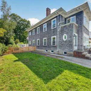 Side yard with lawn and a wooden fence beside 370 Maple Street, New Bedford, MA