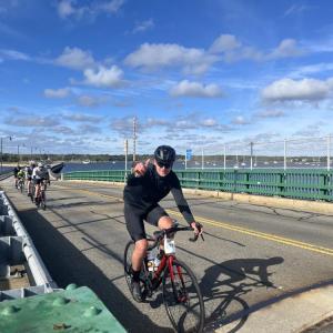 A cyclist gives a thumbs up as he passes over the bridge. 