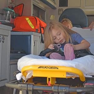 Hazely, age 4, buckles herself into the ambulance. 