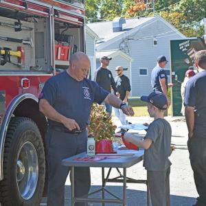 Abraham gets some free fire department merch. 