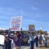 People walk along the road with their signs. Photos by Kat Sheridan
