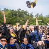 The students toss their caps in the air in celebration. Source: David James 