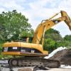 An excavator near a pile of contaminated soil at the former staging site on McCabe Street. Photo by Chris Shea